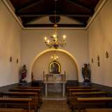 Entriamo. In un attimo ci ritroviamo in un piccolo ma suggestivo ambiente a navata unica illuminato da due lampadari da soffitto e quattro candelabri